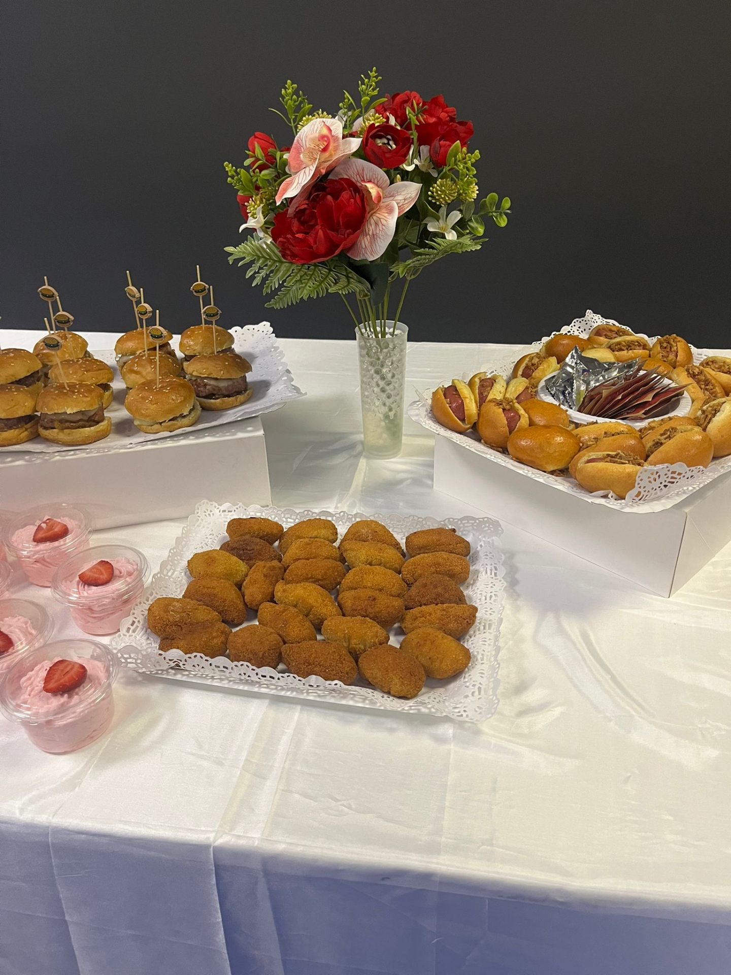 Mesa completa con hamburguesas, frankfurts y postres